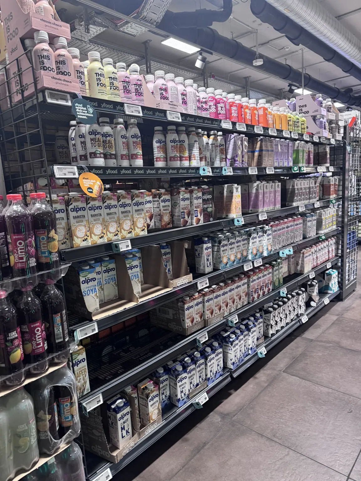 Photo prise en magasin : rayon de boissons végétales, une étagère vide en bas à gauche, sur la deuxième étagère.